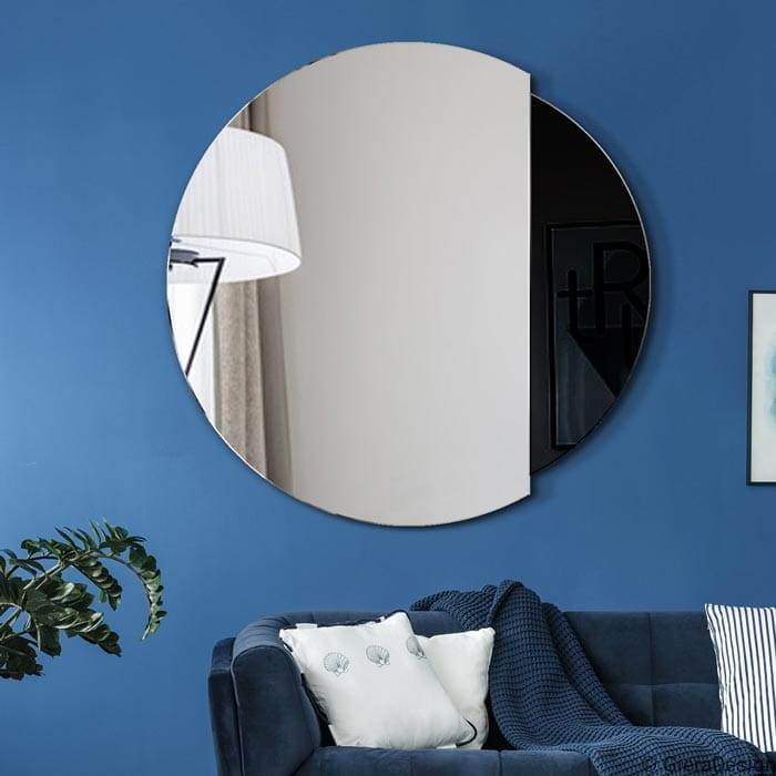 Lustro Eclipse czarne okrągłe do salonu. Zawieszone nad kanapą na niebieskiej ścianie w salonie GieraDesign