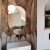 Lustro Ring Ambient owalne w mosiężnej ramie na tle orientalnej tapety. GieraDesign