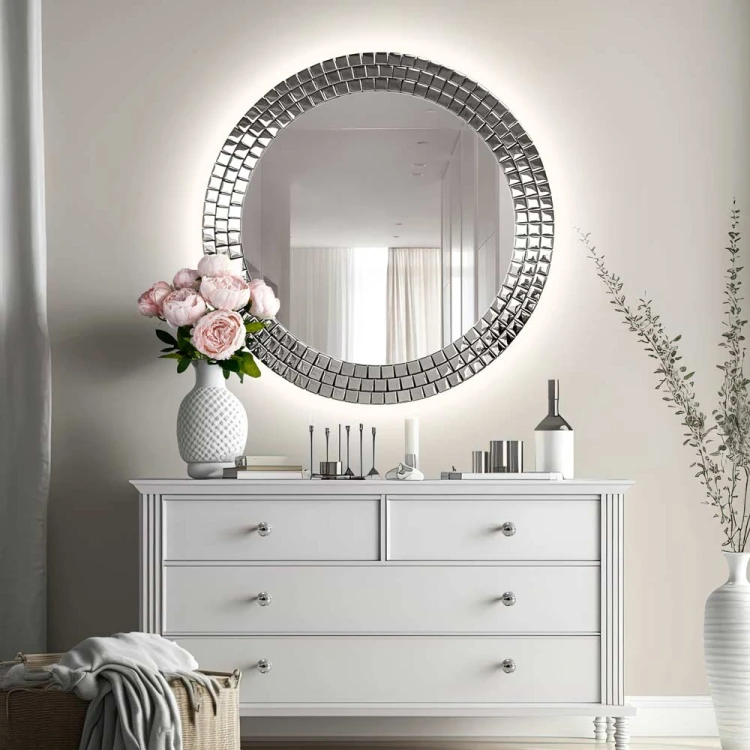 Lustro Aurora Silver podświetlane w srebrnej ramie glamour zawieszone nad białą komodą. GieraDesign