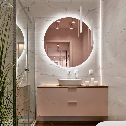Lustro miedziane okrągłe, podświetlane w łazience nad łososiową szafką. GieraDesign