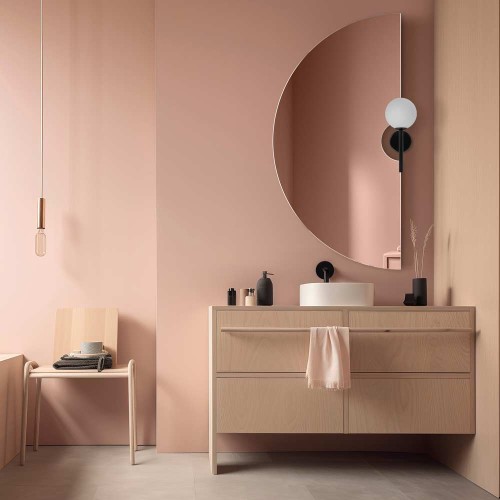 Lustro Pico półokrągłe z wycięciem na kinkiet w jasnej, łososiowej łazience. GieraDesign