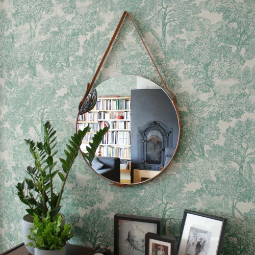 Lustro Eclecti na pasku z rudej skóry wiszące nad komodą. GieraDesign