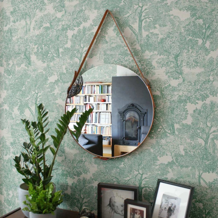 Lustro Eclecti na pasku z rudej skóry wiszące nad komodą. GieraDesign