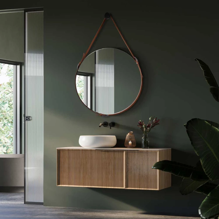 Lustro wiszące na brązowym pasku ze skóry w zielonej nowoczesnej łazience. GieraDesign