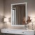 Lustro prostokątne w białej ramie ze srebrną mozaiką, nad konsolą glamour. GieraDesign