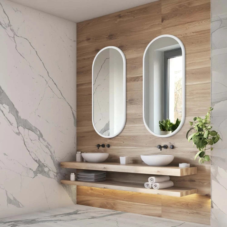 Lustro Ambient owalne w białej ramie w nowoczesnej łazience z elementami marmuru i drewna, GieraDesign