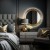 Dekoracyjne okrągłe lustro w złotej ramie podświetlane nad komodą w sypialni w stylu glamour. GieraDesign
