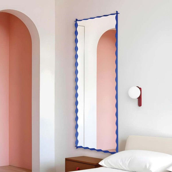 Lustro Monda Wave w niebieskiej pofalowanej ramie zawieszone w sypialni. Lustro GieraDesign