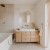 Łukowe lustro Portal w białej ramie nad szafką z umywalką w jasnej, nowoczesnej łazience. GieraDesign