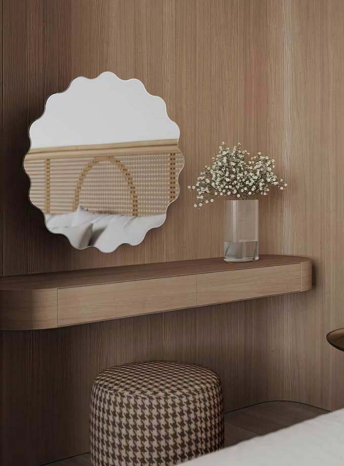 Lustro Holly okrągłe z falowanymi krawędziami, zawieszone nad toaletką w sypialni. GieraDesign