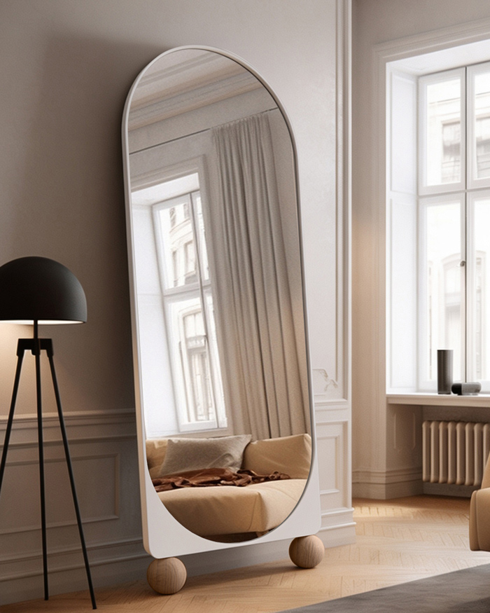Lustro łukowe z kulami, białe oparte o ścianę w salonie. GieraDesign