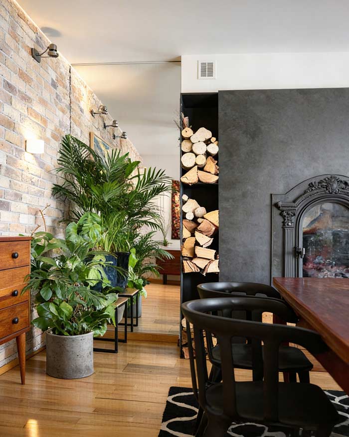 Lustro na wymiar we wnęce obok kominka w salonie sprawia wrażenie jakby było drugie pomieszczenie