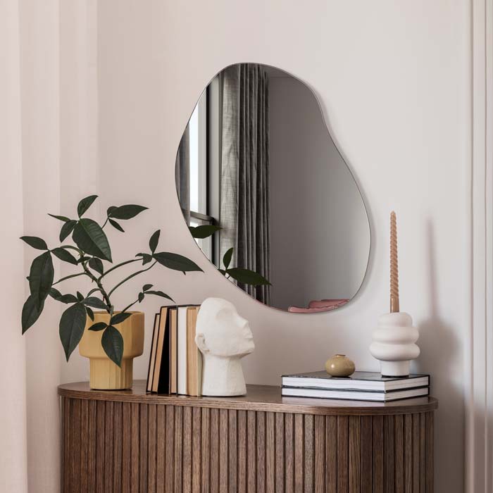 Nieregularne lustro Plama no.3 w aranżacji z dodatkami nad komodą w nowoczesnym salonie